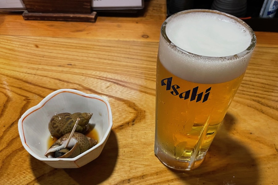 【かめ福】ビール、お通しのバイ貝の煮付け